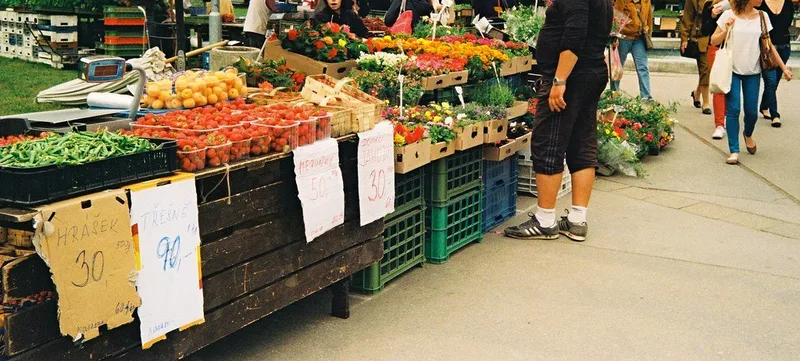 野菜と果物が並ぶ屋外の市場の店先の写真